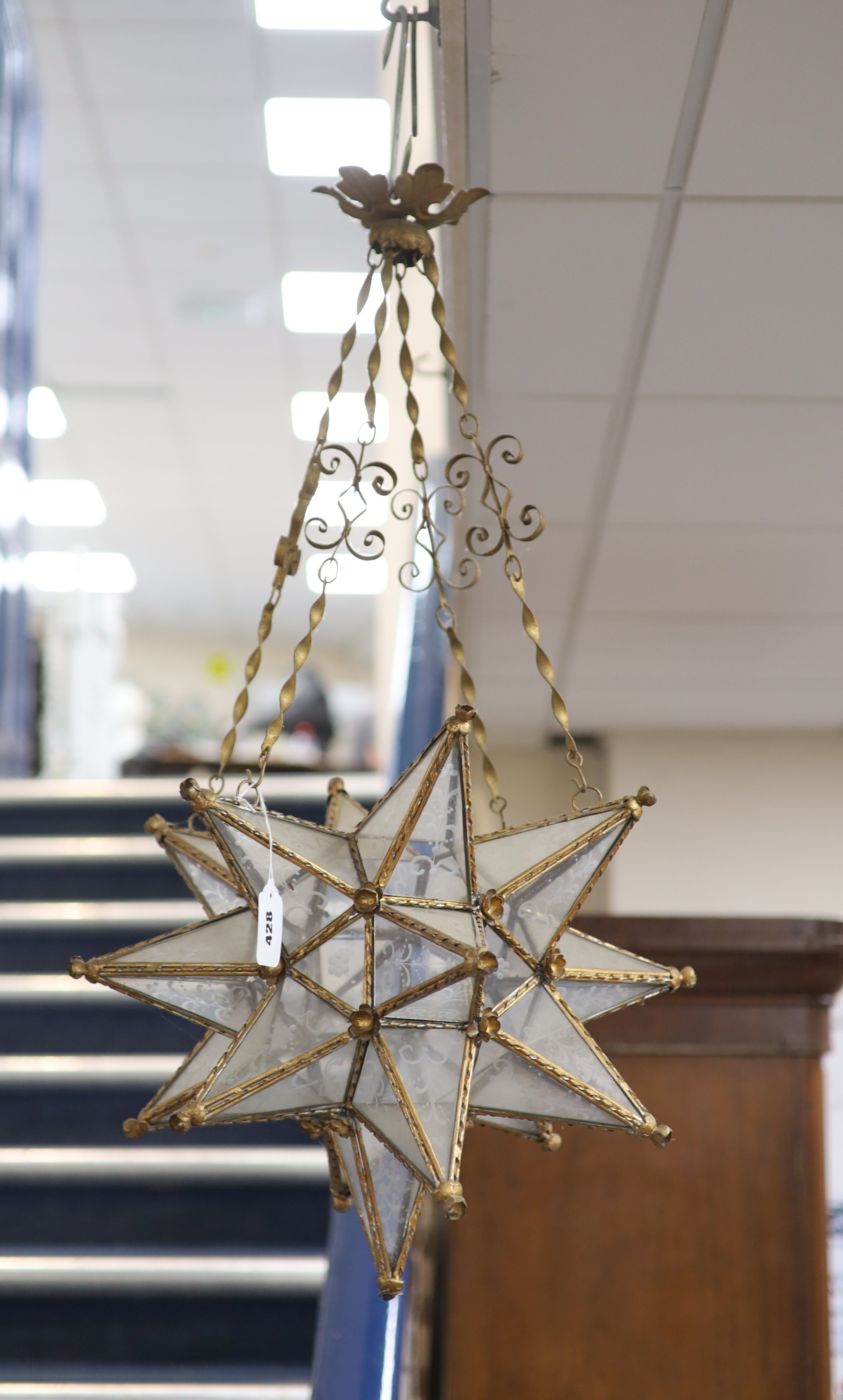 A gilt-metal star-shaped ceiling light, having etched plain glass panels and chain suspension, height 80cm